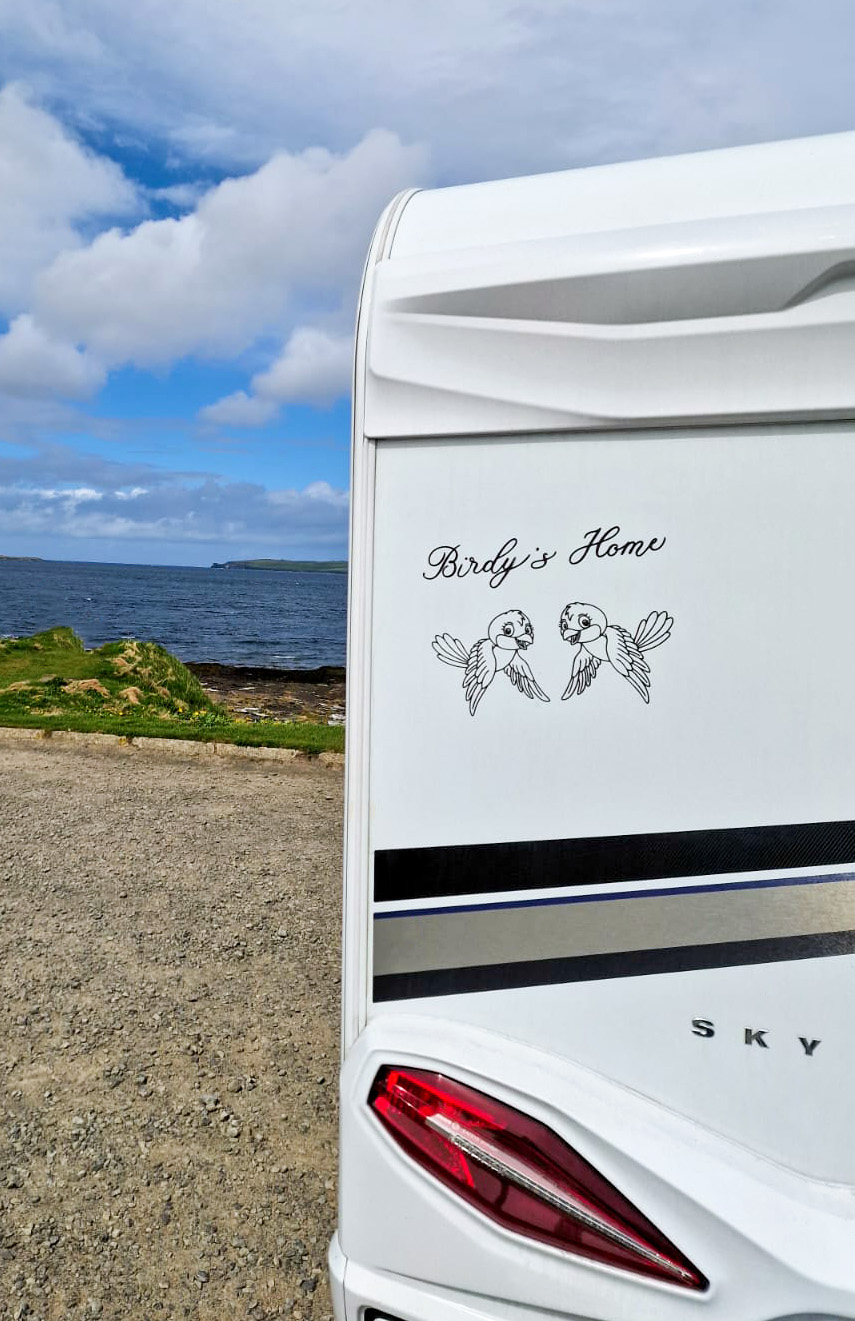 Beschrifteter Wohnwagen «Birdy’s Home» in der Landschaft